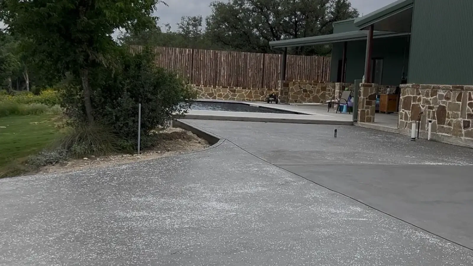 Finished broom-swept concrete driveway and pool deck at a Texas Hill Country property near Kerrville
